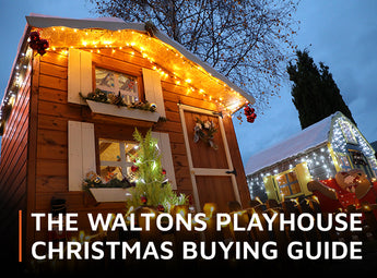 Wooden playhouse illuminated with Christmas string lights with overlay wording 'The Waltons Playhouse Christmas Buying Guide'