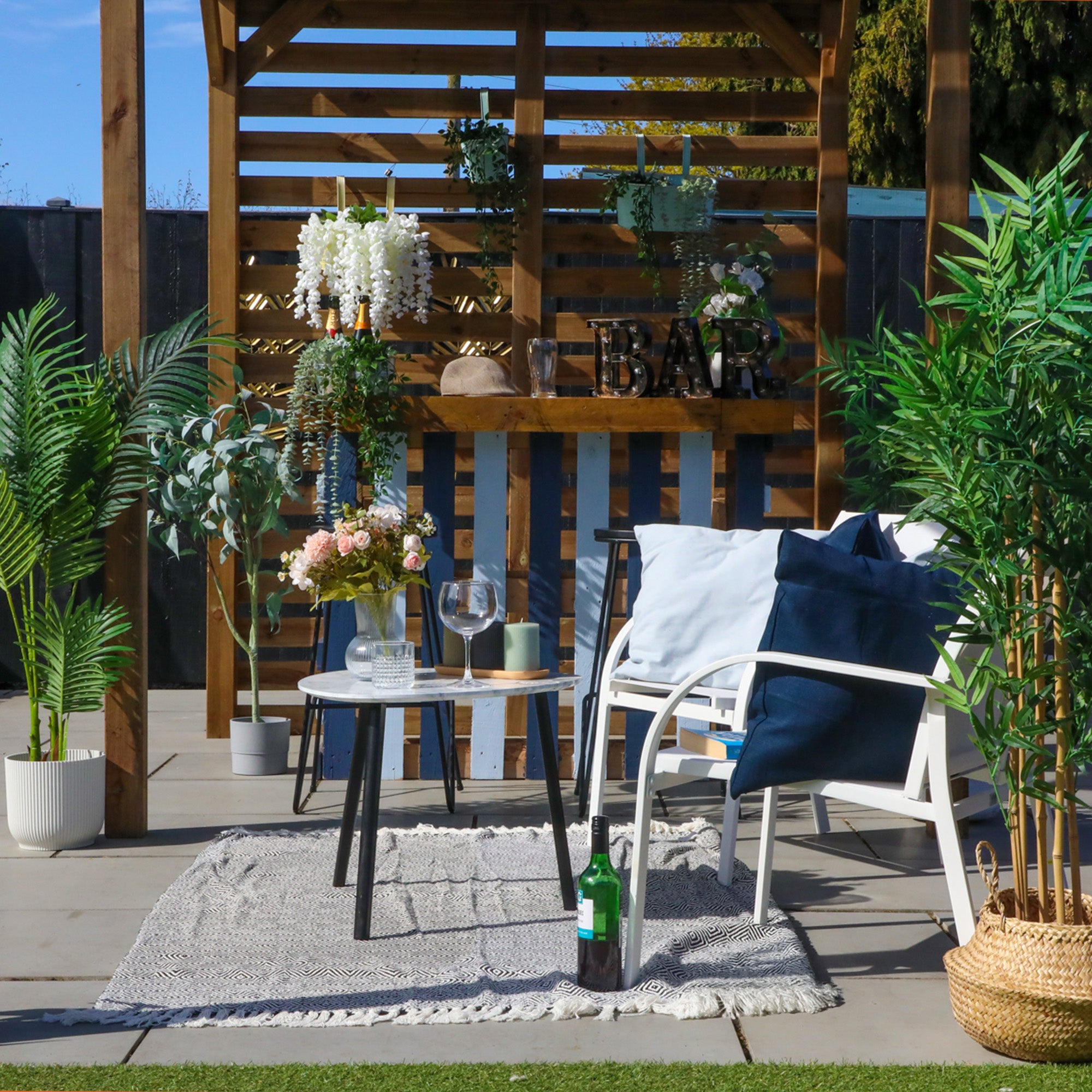 Neatly decorated interior of a gazebo with a bar and some garden chairs.