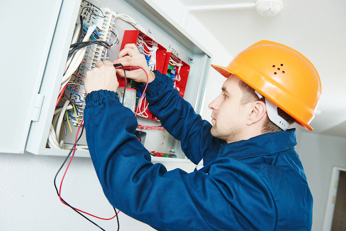 Electrician working on a fuse box Electrician working on a fuse box