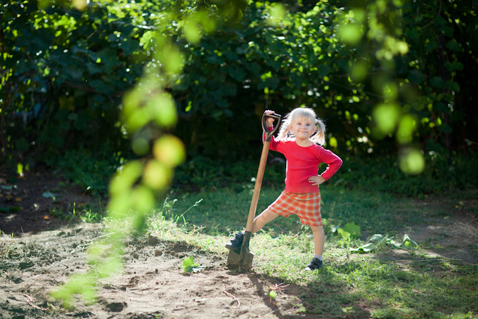 Little girl in garden with shovel Little girl in garden with shovel