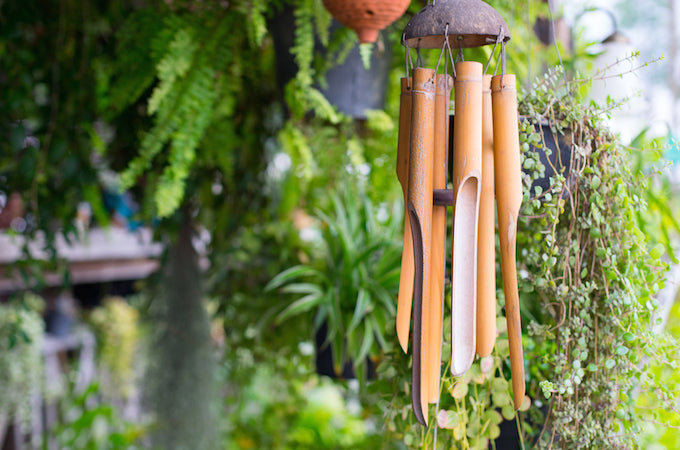 closeup of wooden wind chimes against a green leafy background