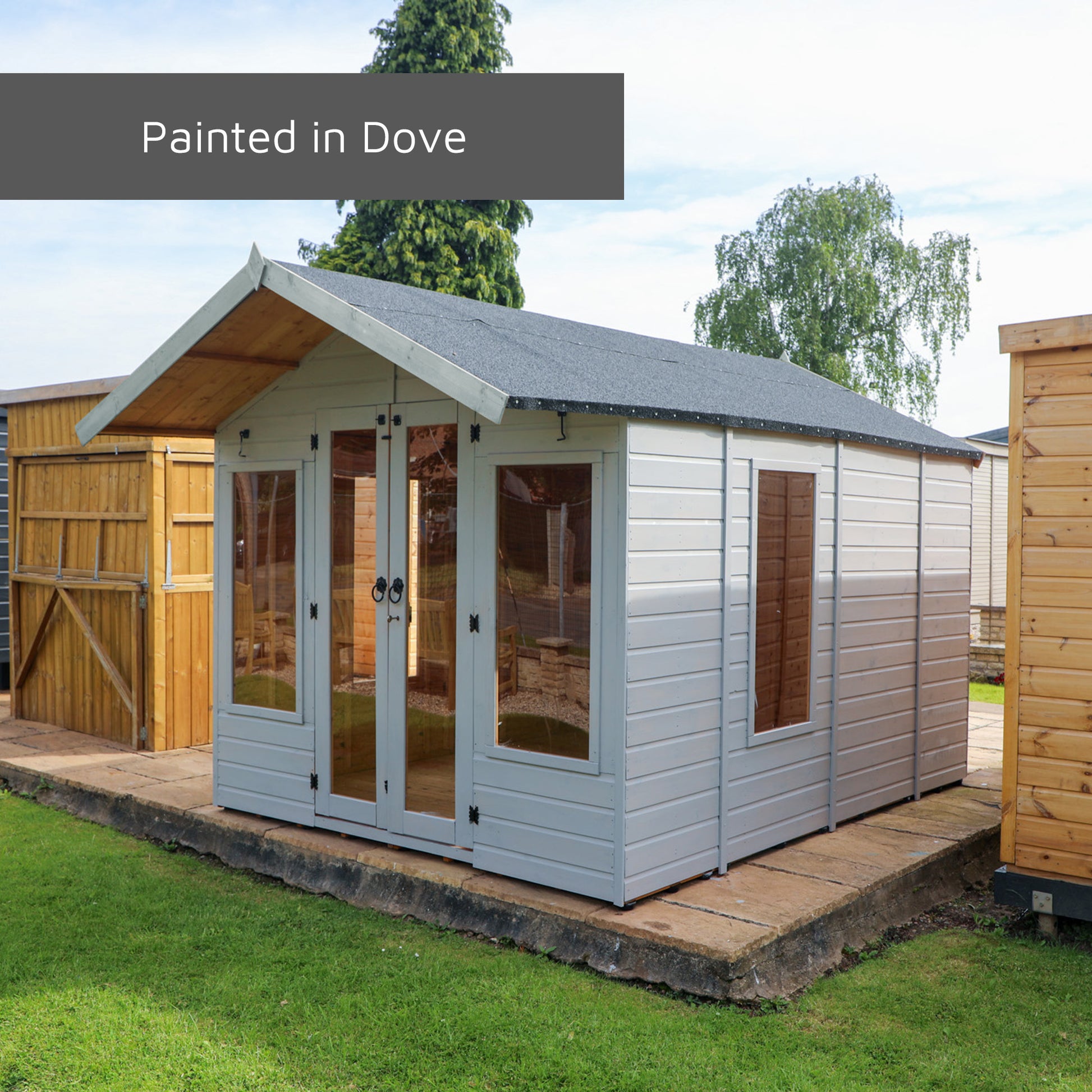 A summerhouse with double doors painted in a pale grey colour