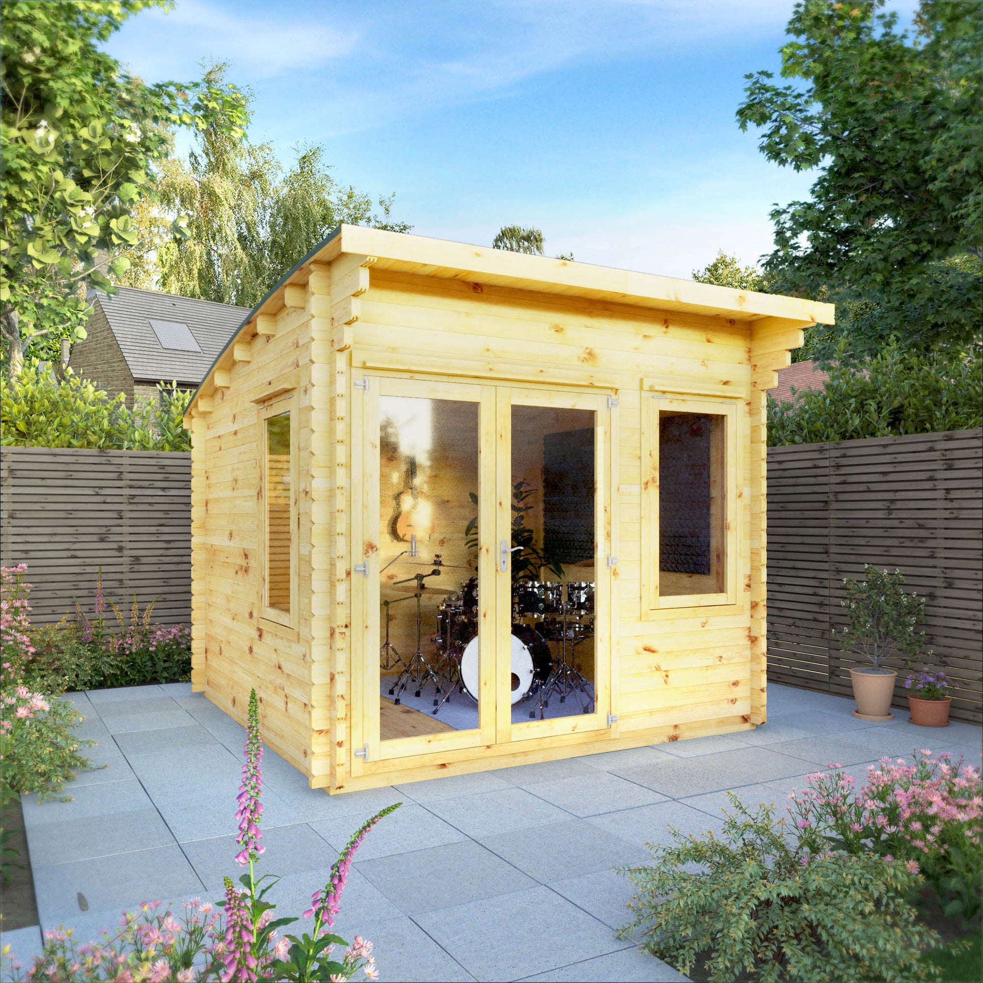 A curved roof log cabin with full length double doors and large windows, being used as a music room in a flowery British garden
