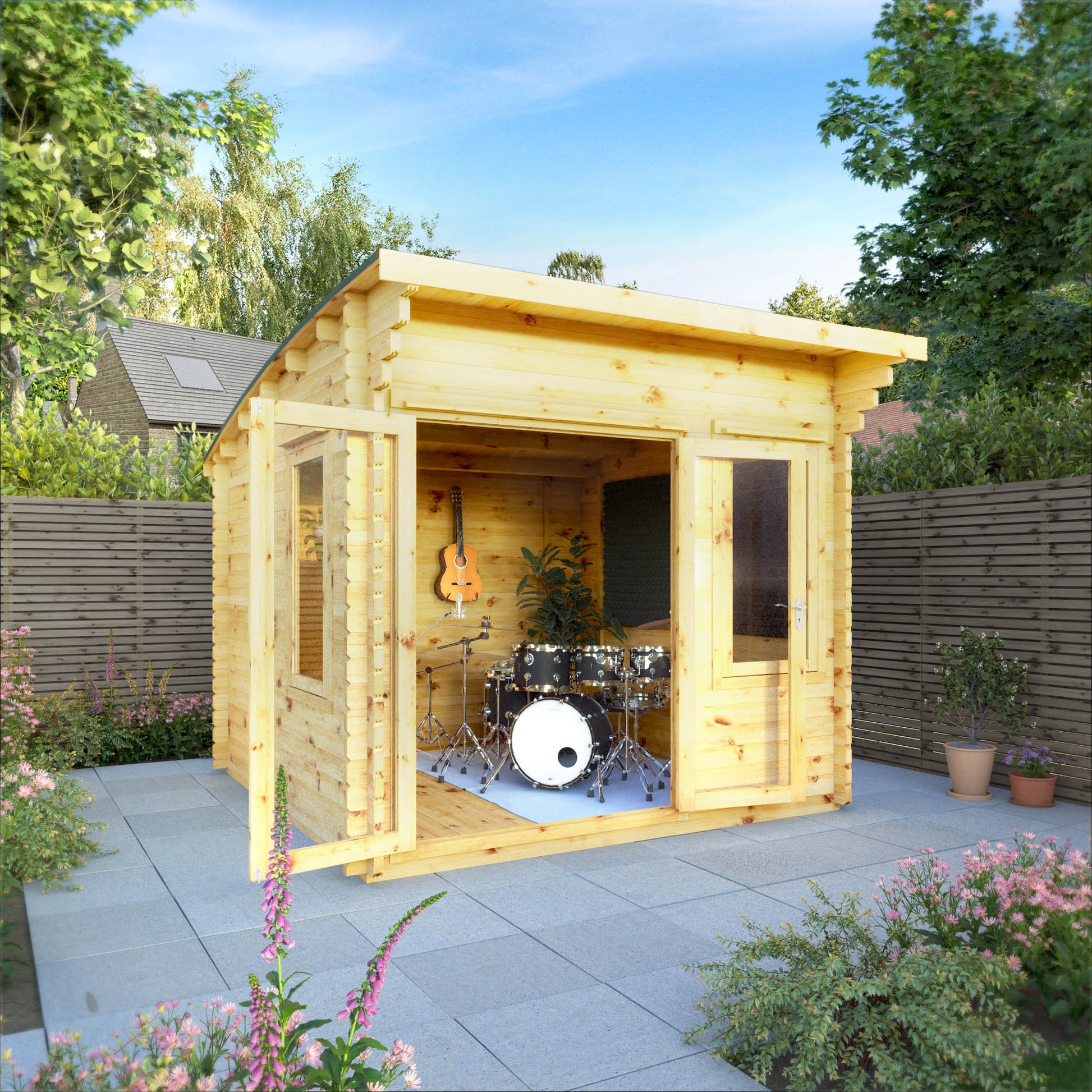 A curved roof log cabin with full length double doors and large windows, being used as a music room in a flowery British garden