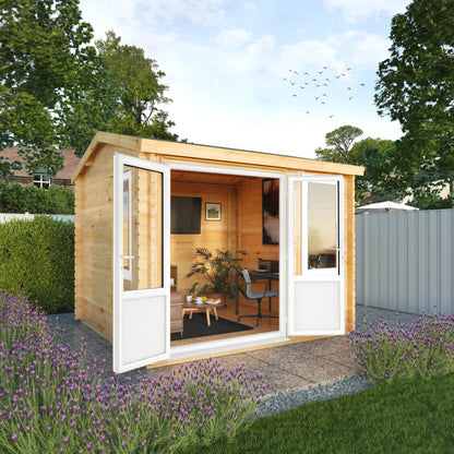 A small log cabin made from wood, with a pitched roof, double doors, in a flowery English garden on a patio with white UPVC