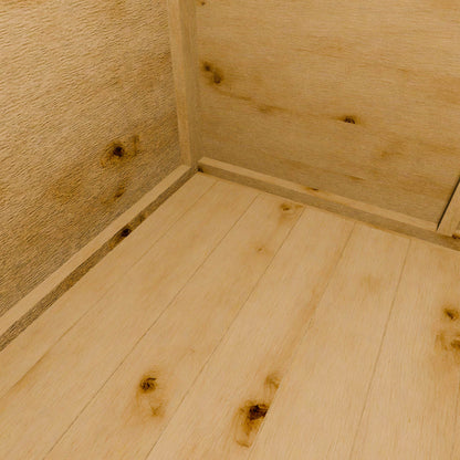 Close-up of a wooden shed floor with visible grain and knots