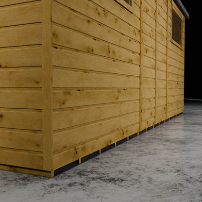 Wooden shiplap shed wall with styrene windows in a darkened setting.