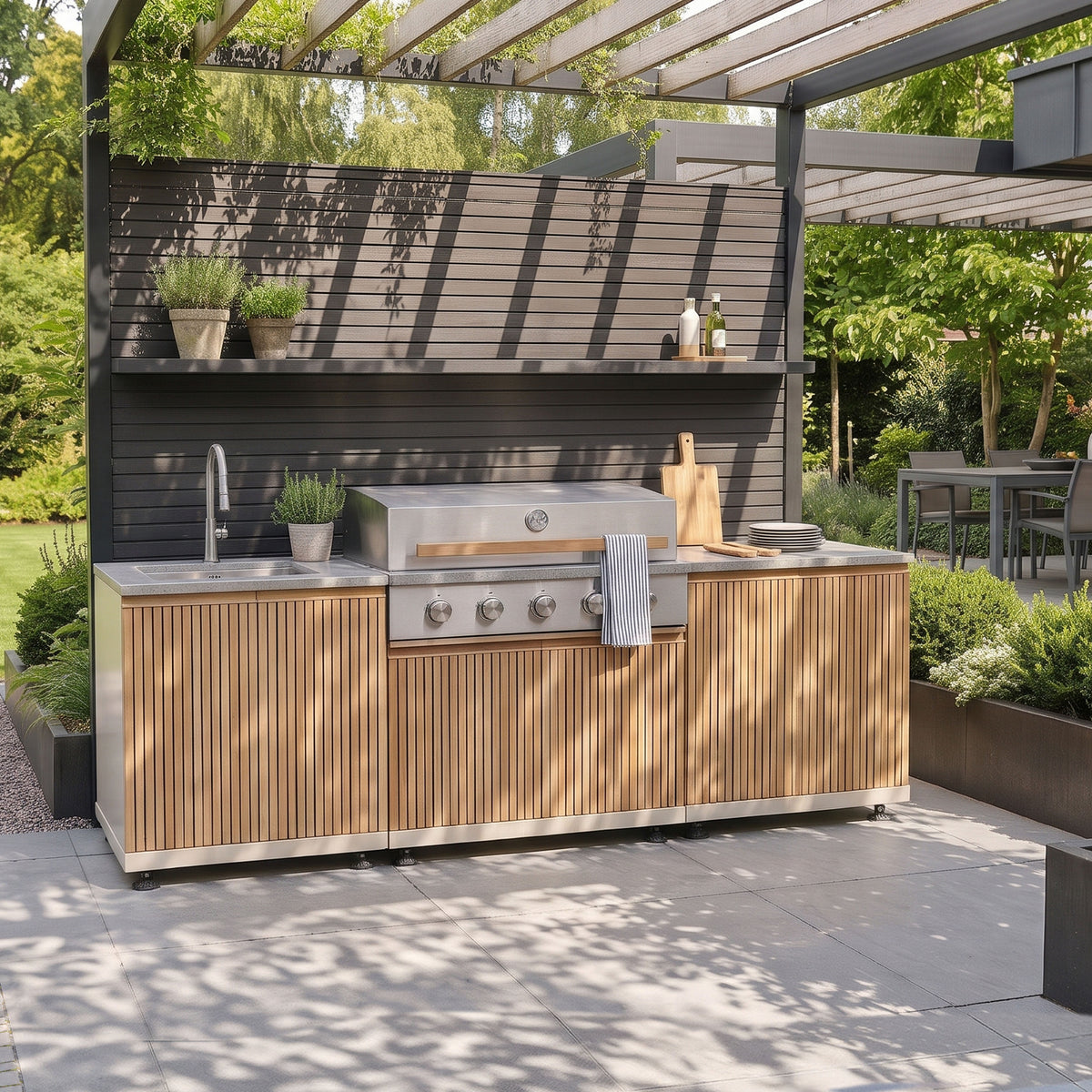 Skogen Small Outdoor Kitchen with Sink in Latte, with slatted door fronts and a grey worktop, on a garden patio