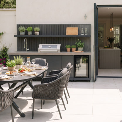 Waltons Strata Signature Outdoor Kitchen in Grey on a pale stone patio next to open bifold doors