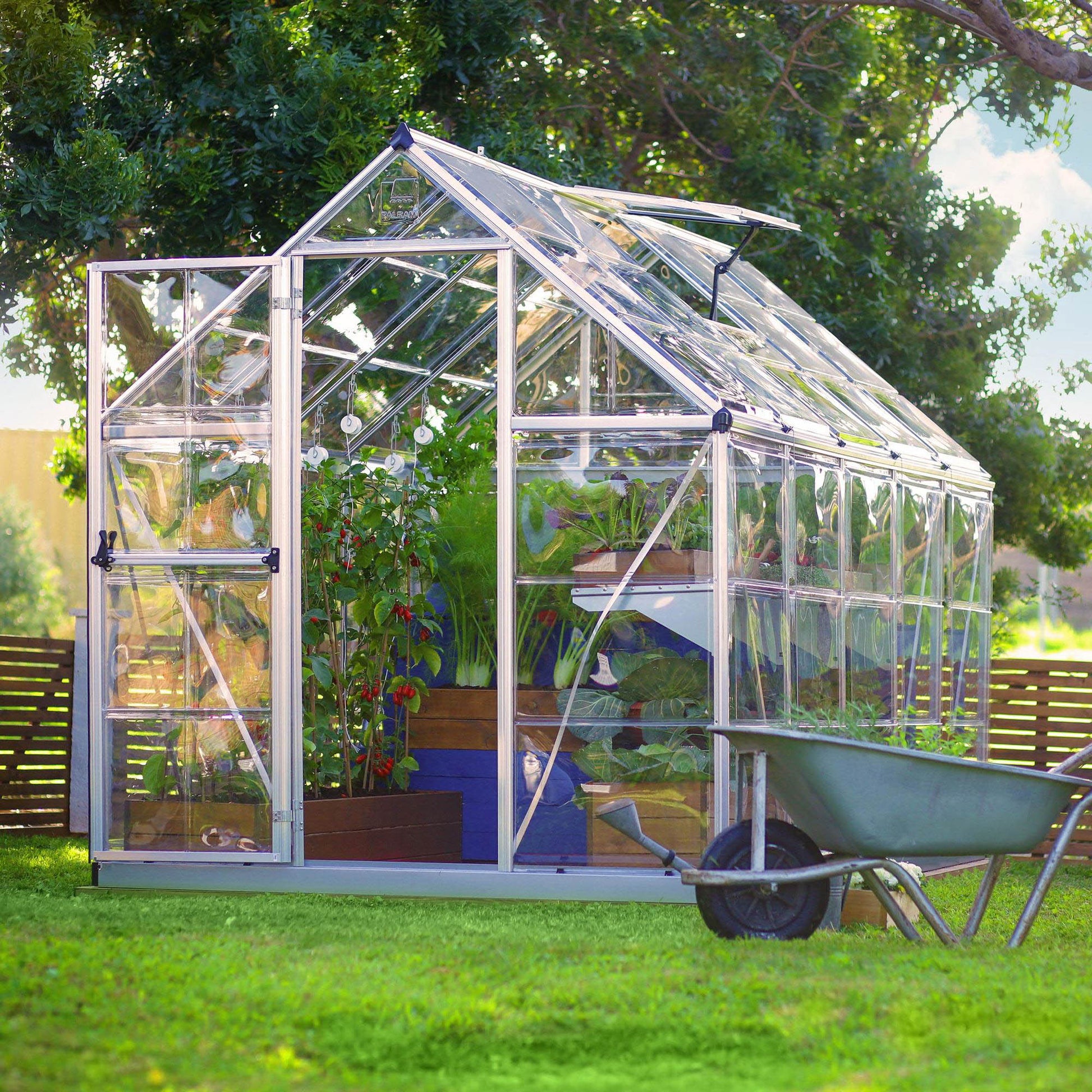 A greenhouse made up of windows with silver metal framing