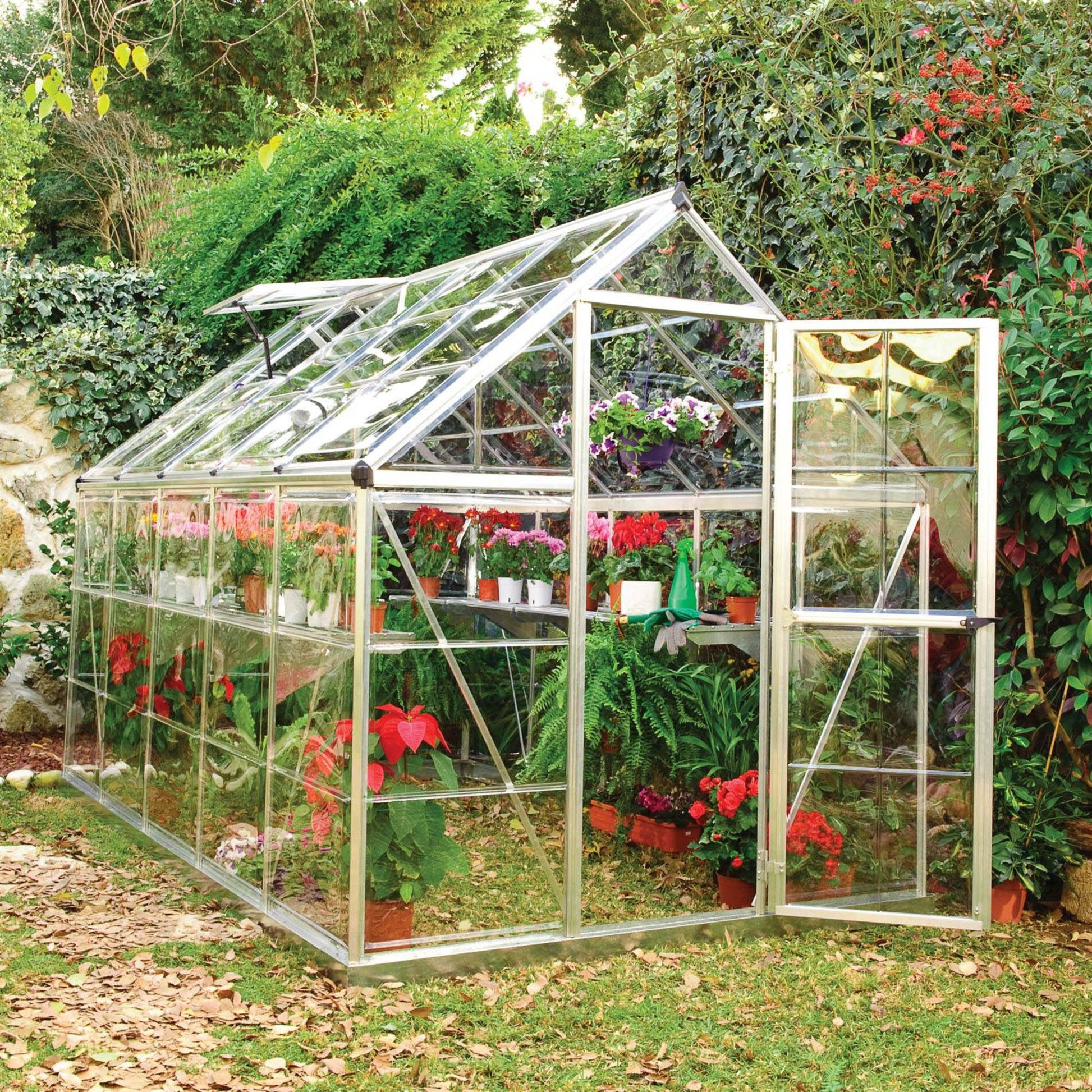 A greenhouse made up of windows with silver metal framing