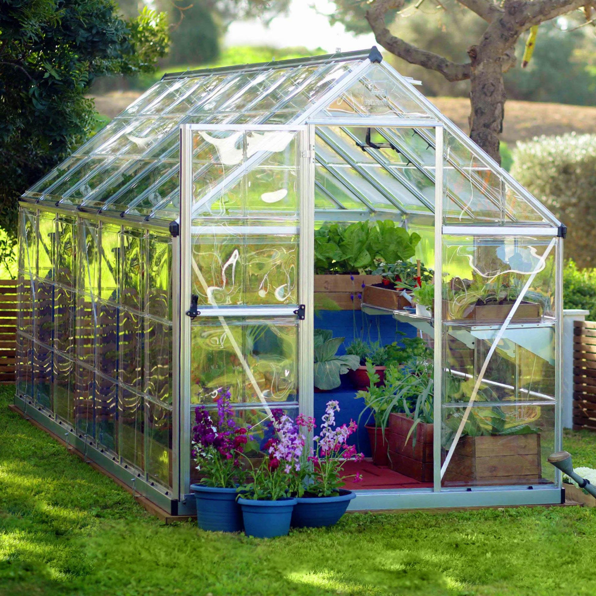 A greenhouse made up of windows with silver metal framing