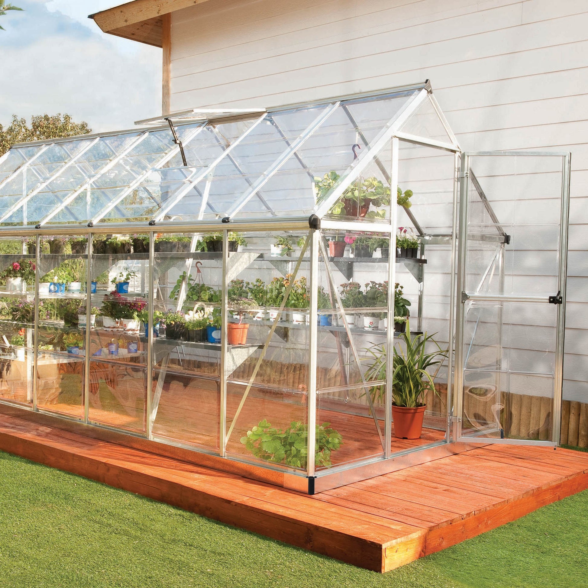 A greenhouse made up of windows with silver metal framing