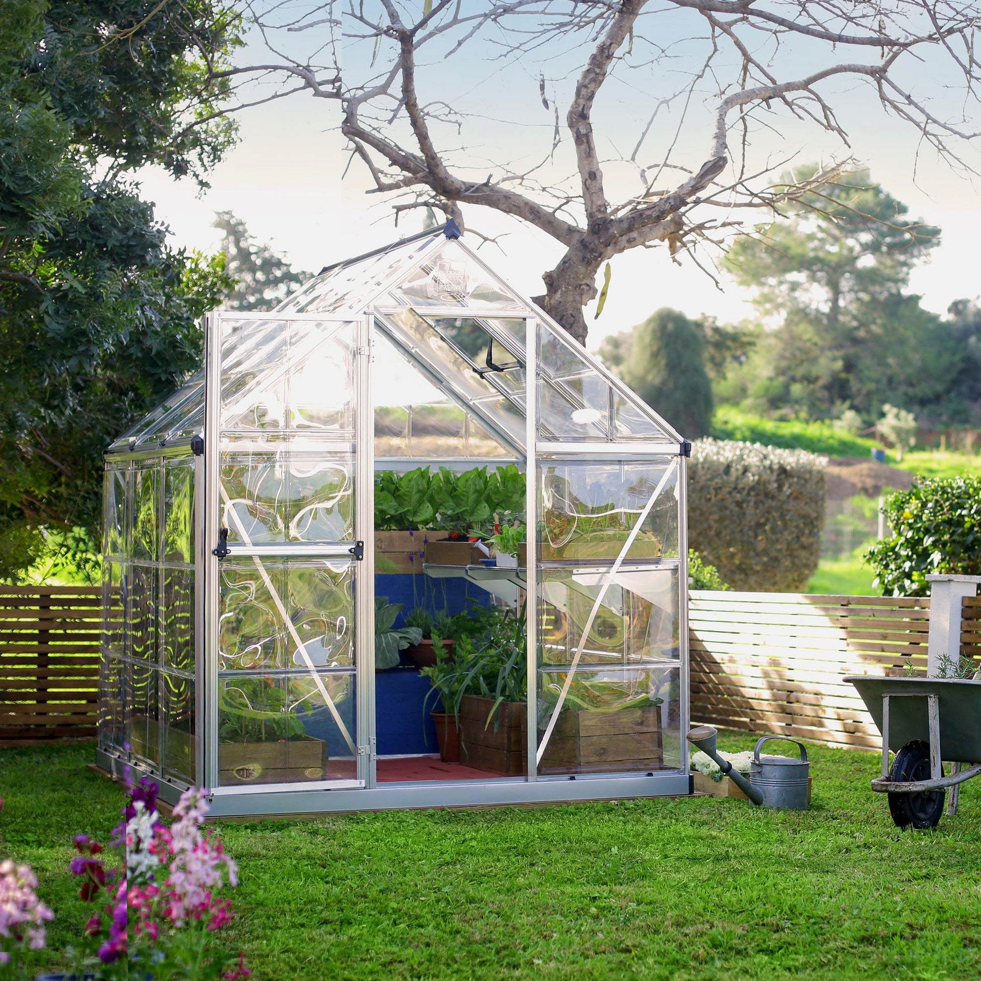 A greenhouse made up of windows with silver metal framing