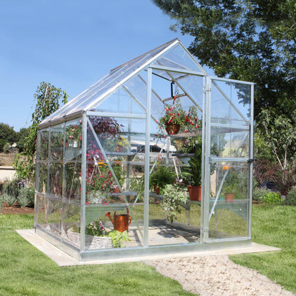 A greenhouse made up of windows with silver metal framing