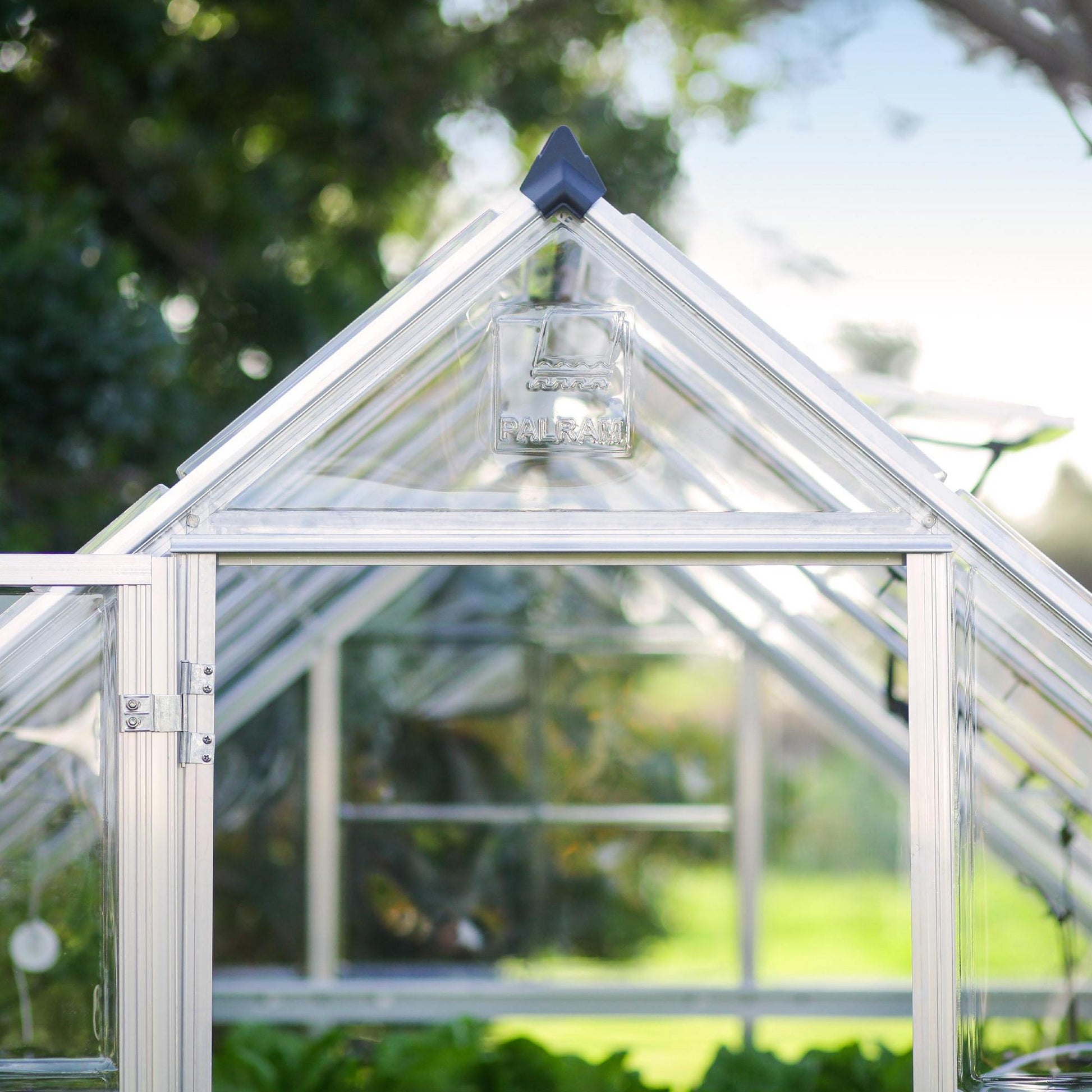 A greenhouse made up of windows with silver metal framing