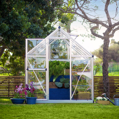 A greenhouse made up of windows with silver metal framing