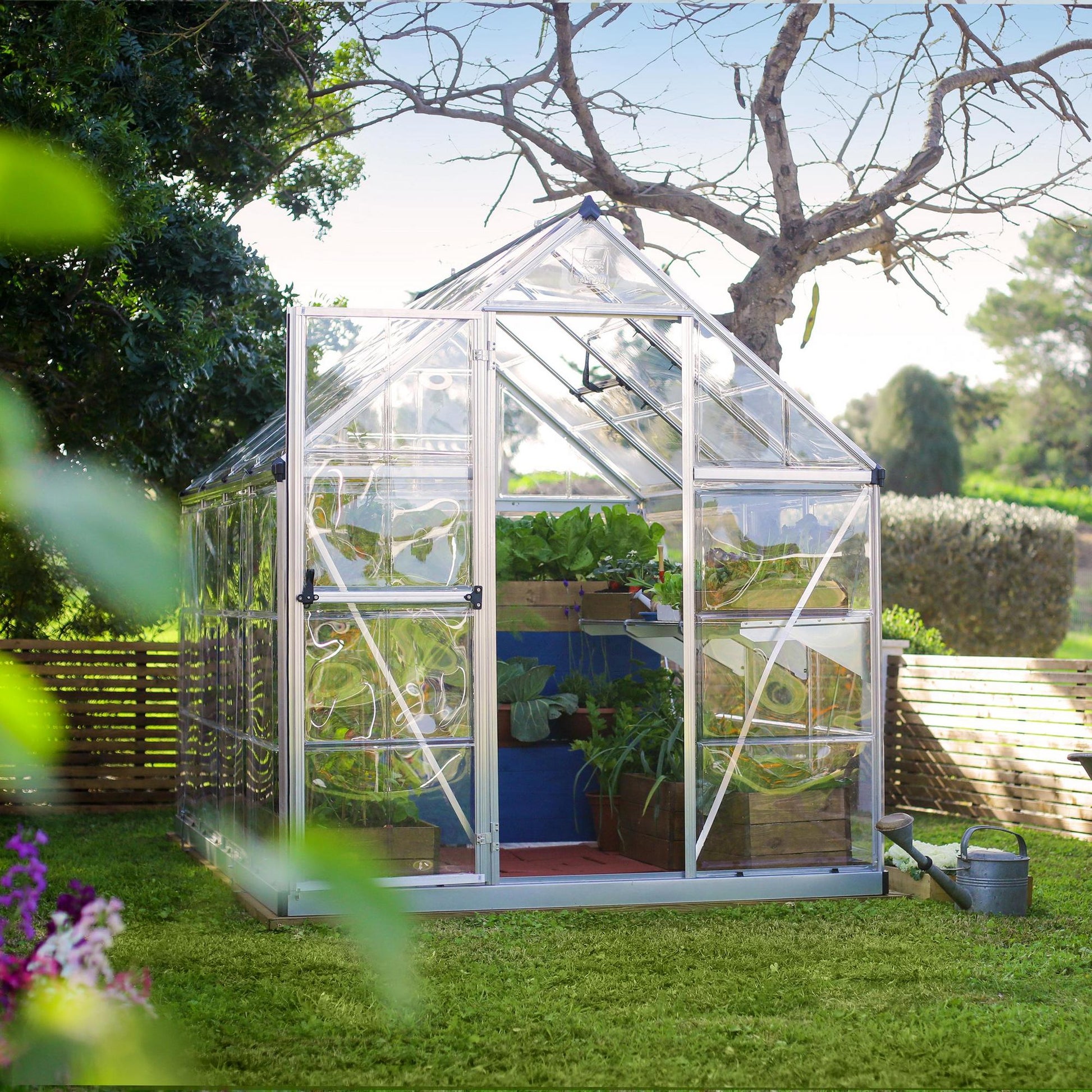 A greenhouse made up of windows with silver metal framing