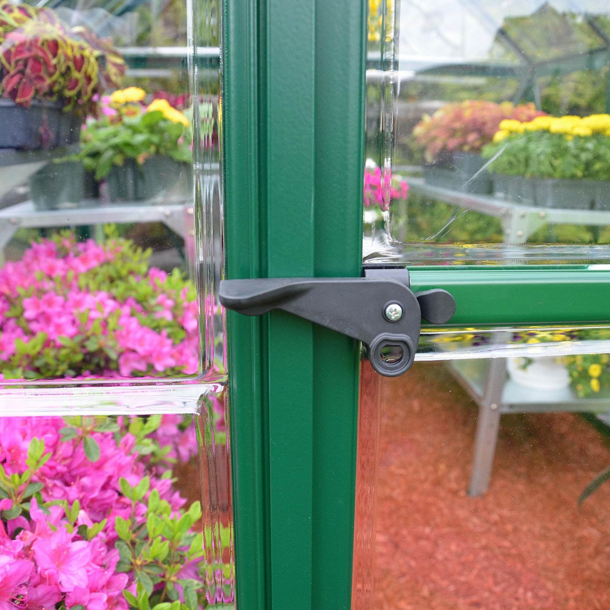 Plastic door handle on a green metal greenhouse