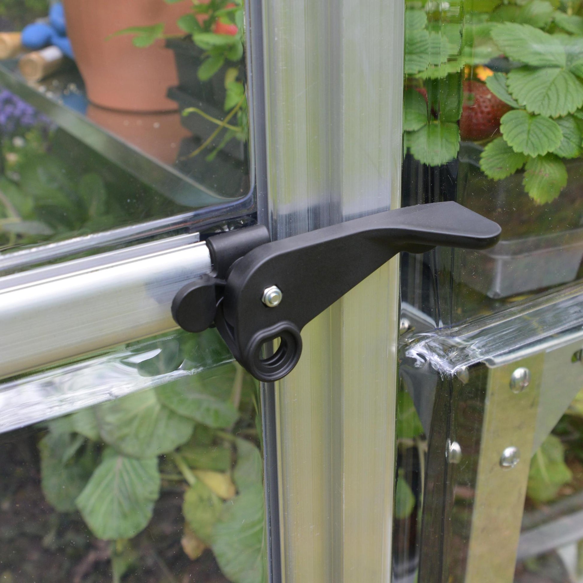 Plastic door handle on a silver metal greenhouse