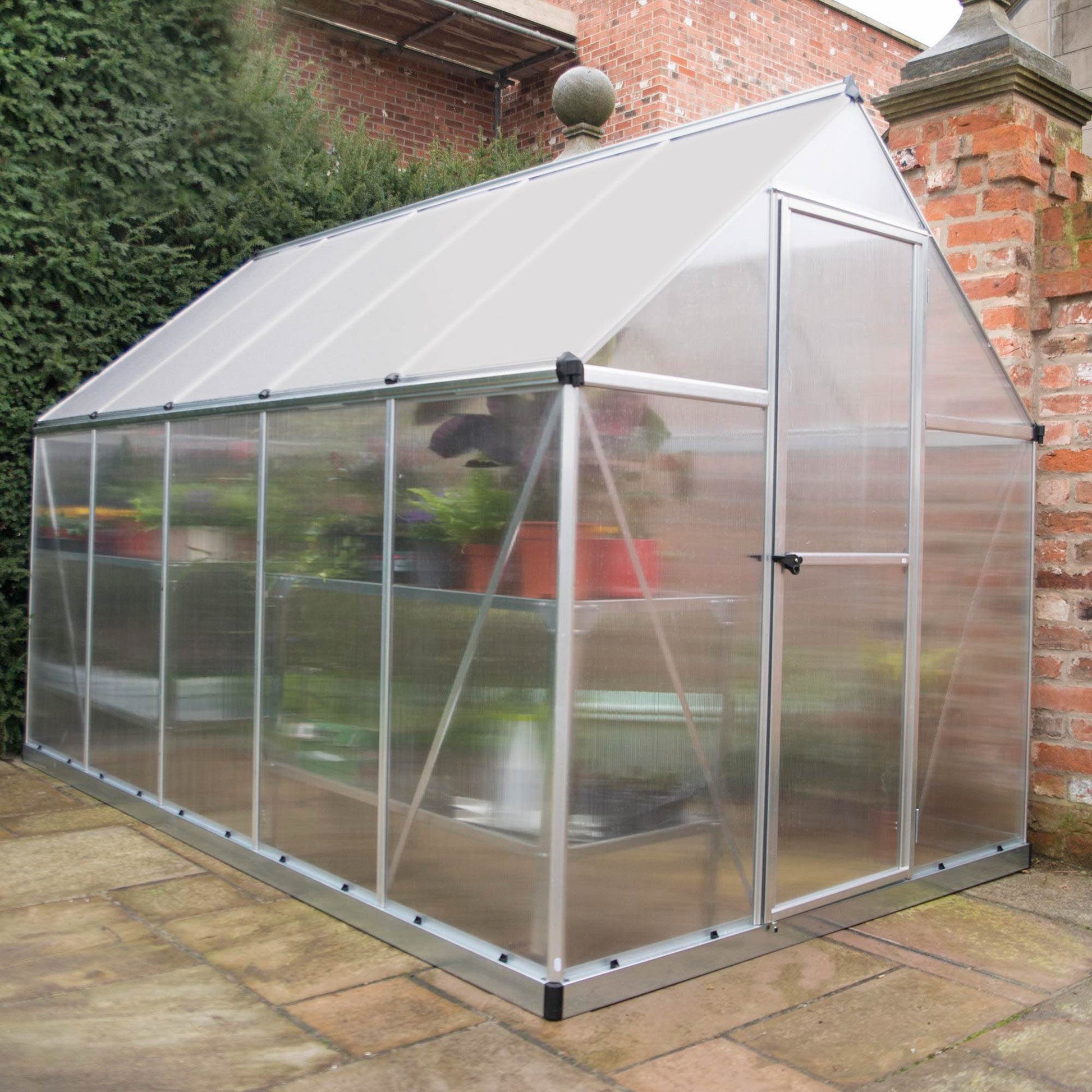 A greenhouse made up of windows with silver metal framing