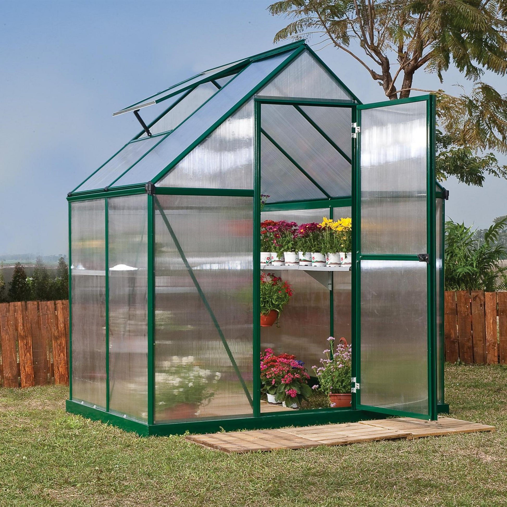 A greenhouse made up of windows with green framing