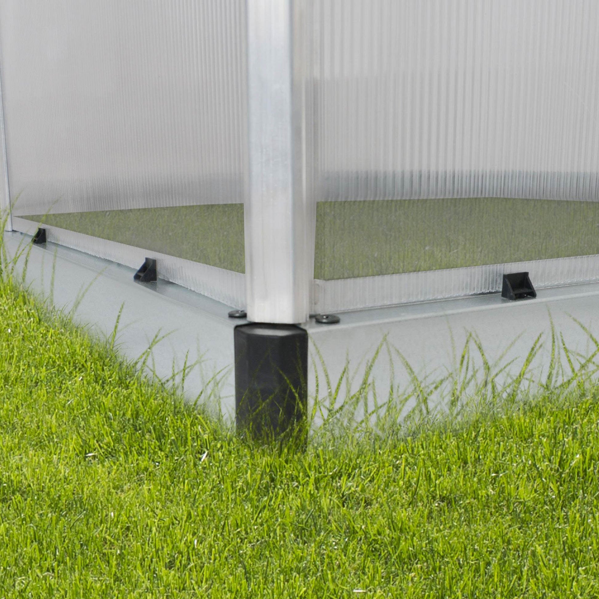 A greenhouse made up of windows with silver metal framing