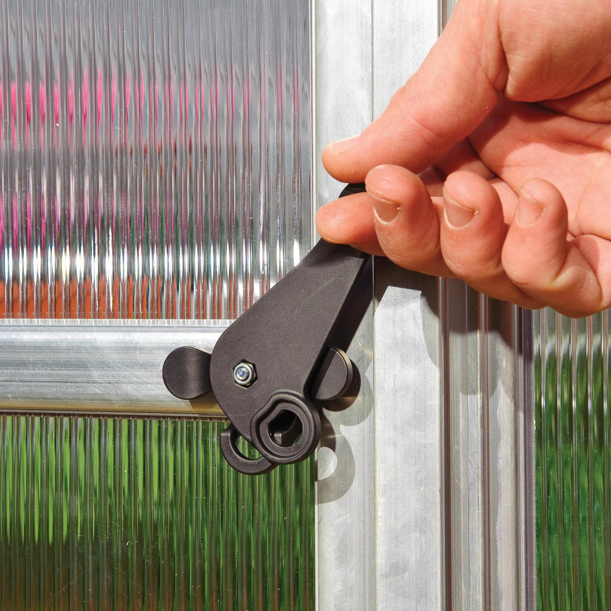 Plastic door handle on a silver metal greenhouse