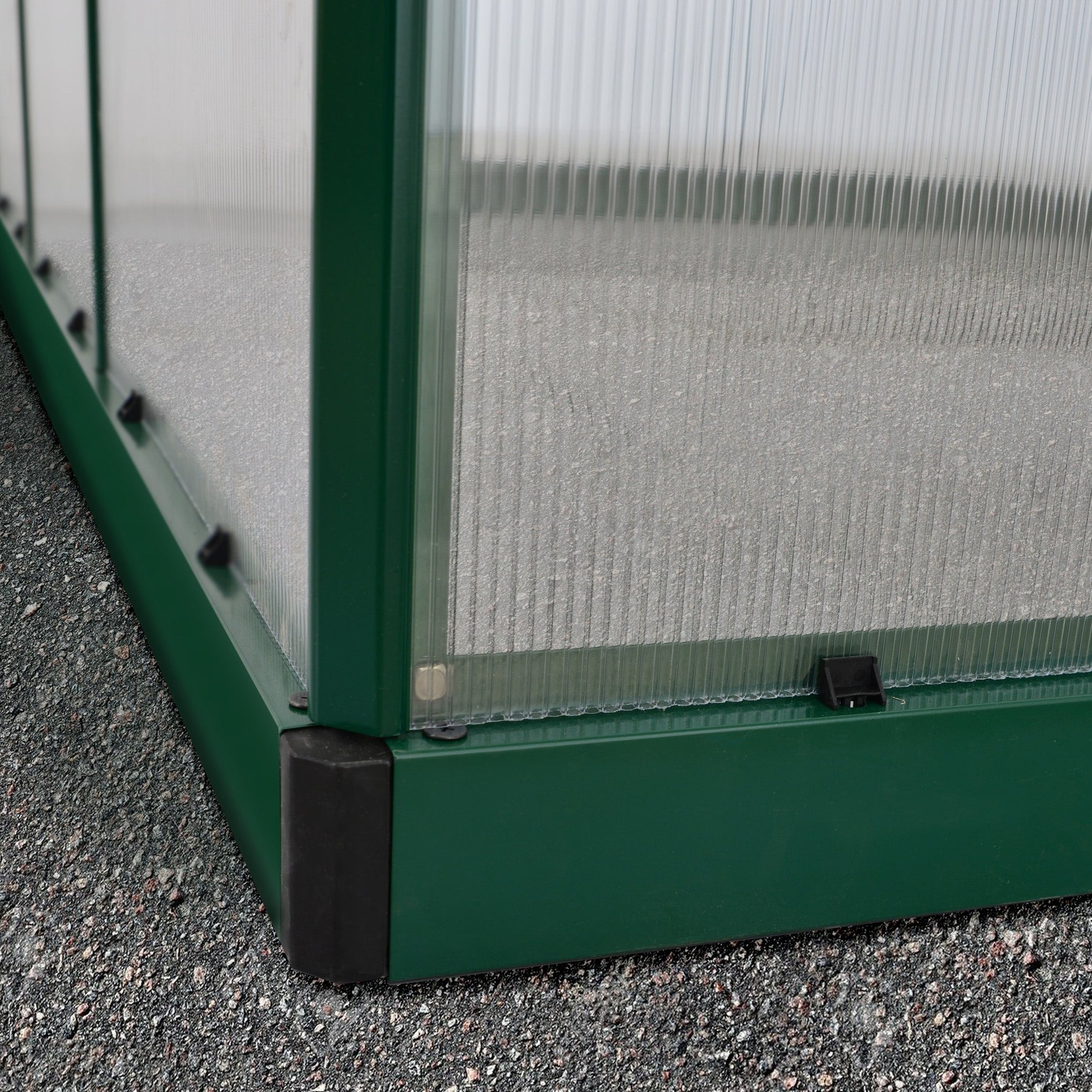 A greenhouse made up of windows with green framing