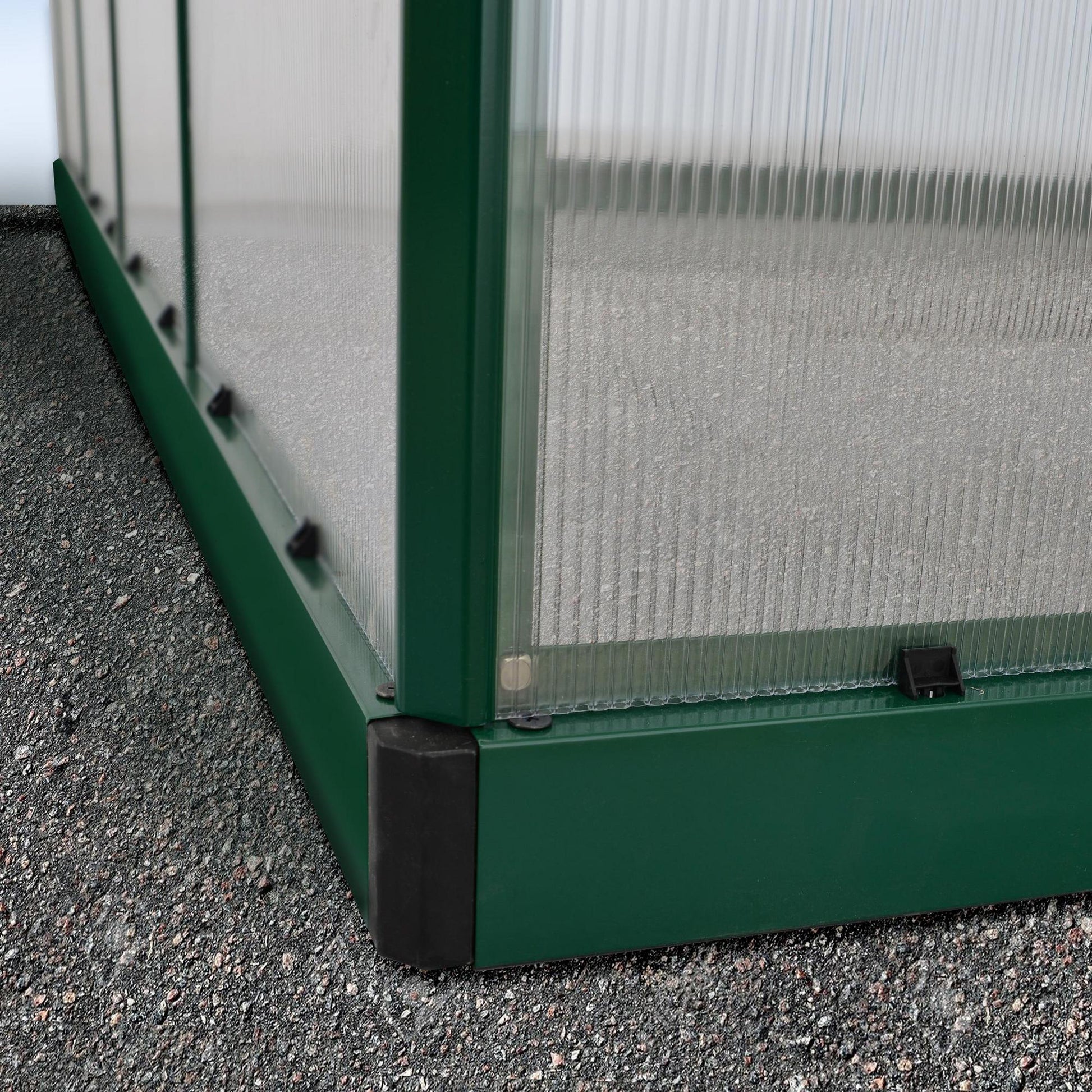 A greenhouse made up of windows with green framing