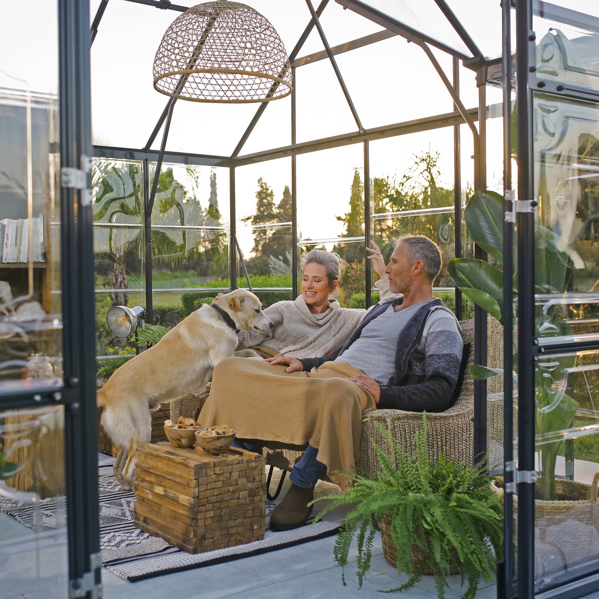 An orangery with an apex roof, made up of windows with grey metal framing