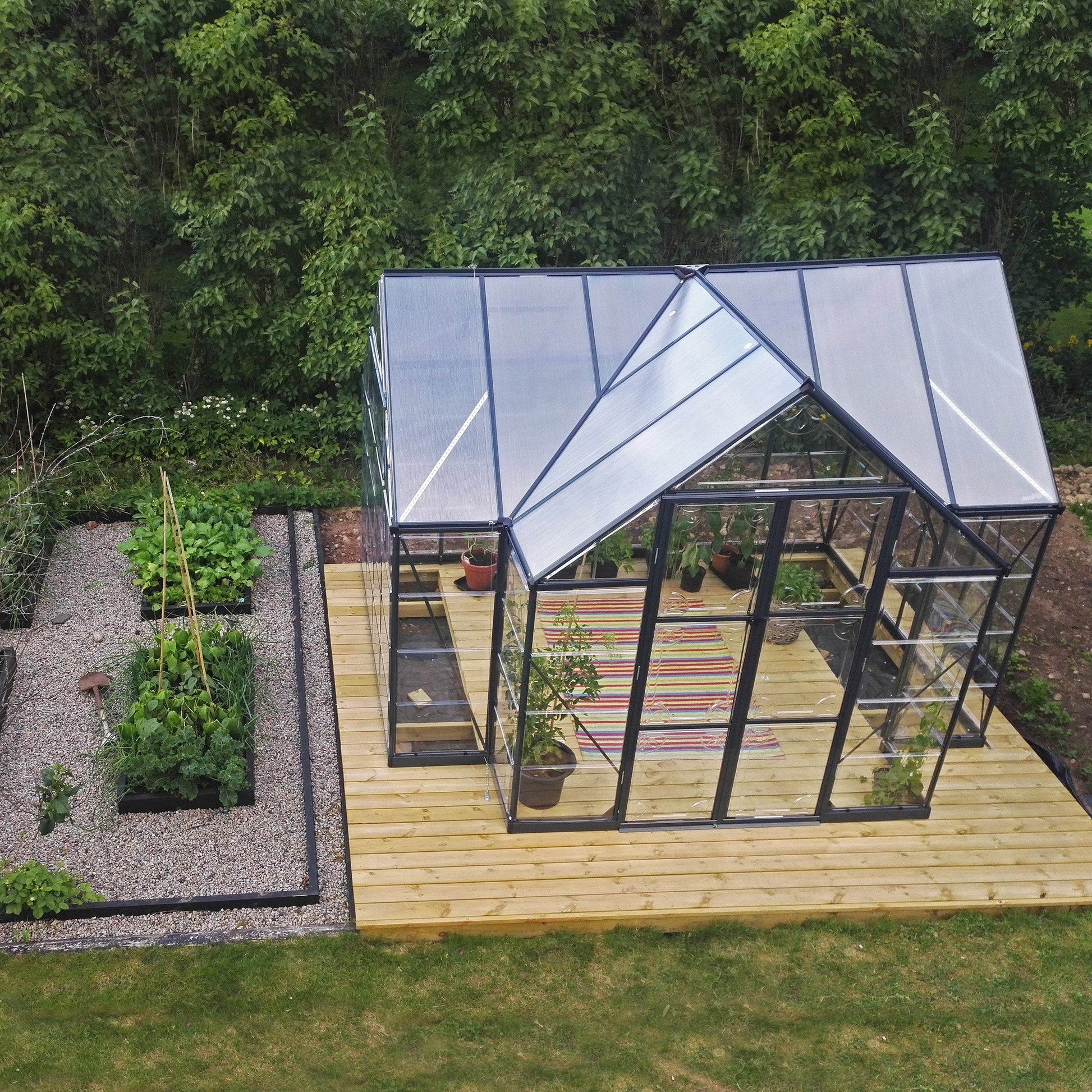 An orangery with an apex roof, made up of windows with grey metal framing
