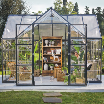 An orangery with an apex roof, made up of windows with grey metal framing